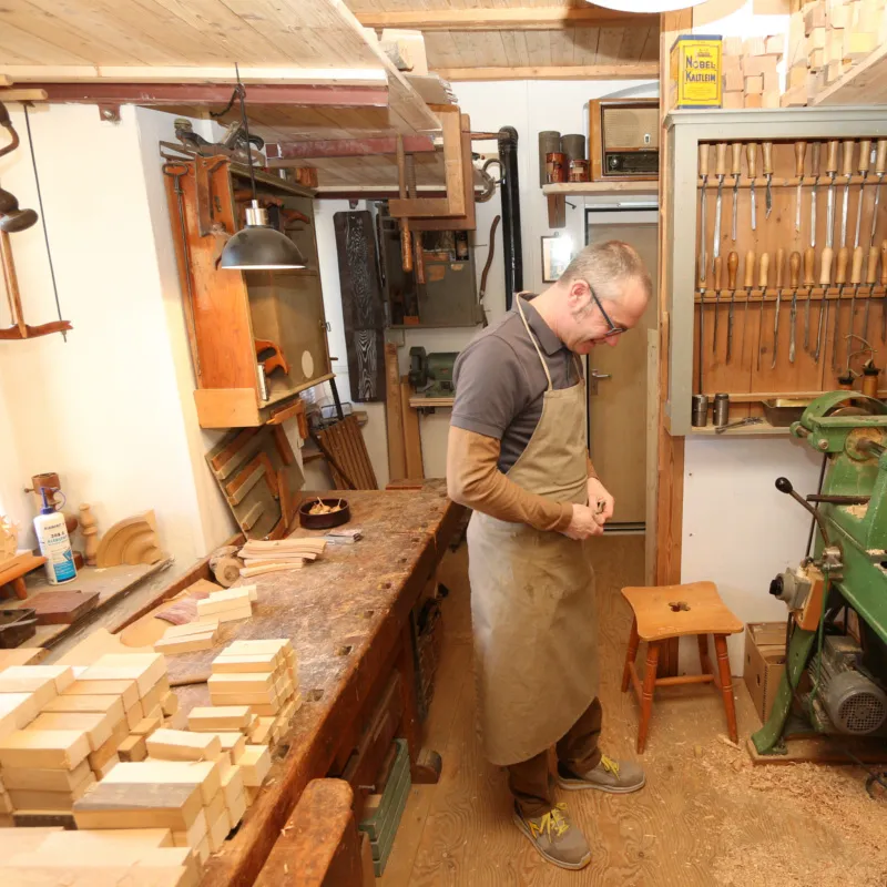 Falk Haberecht steht in seiner Tischlerei und arbeitet an einem Stück Holz